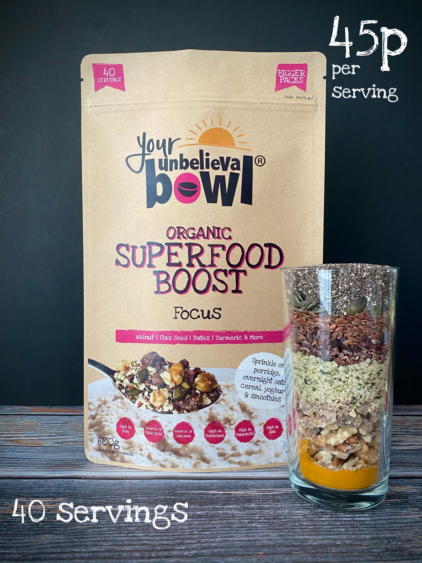 Packaging of 'Your UnbelievaBowl Organic Superfood Boost Focus' with a transparent section showing the mix of superfoods inside, placed next to a glass bowl filled with the same mix.